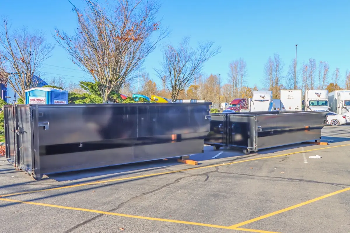 Professional dumpster rental service with roll-off container on residential driveway in Mayfair